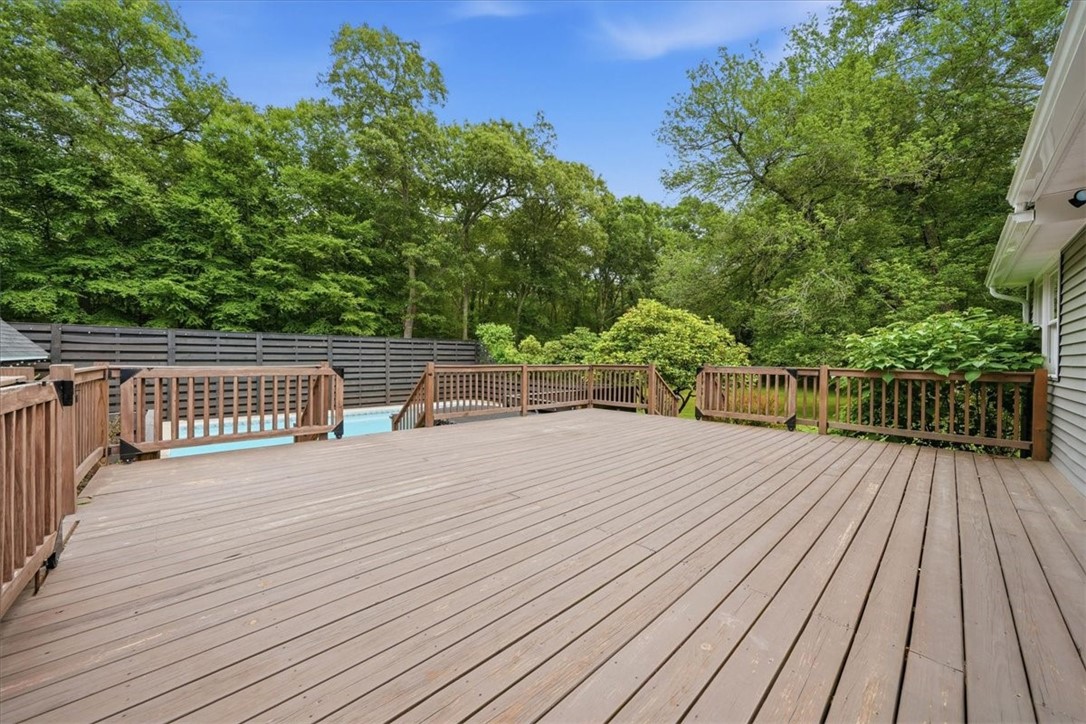 214 Anan Wade Road Glocester, RI 02857 - Photo 33 of 50 Step outside from the kitchen to an enormous entertainment deck that truly expands the home’s living space outdoors. With plenty of room for dining, lounging, grilling, and gathering, this oversized deck is designed for hosting and enjoying the private backyard setting.