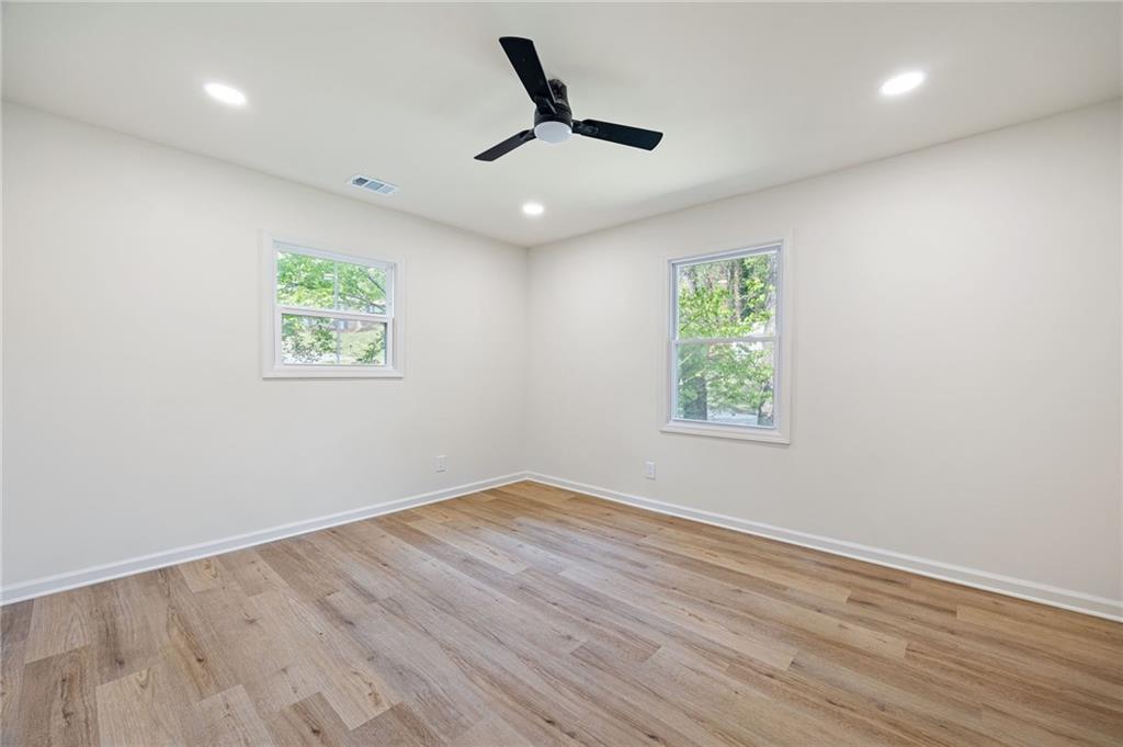 4289 Kimball Road Southwest Atlanta, GA 30331 - Photo 16 of 20 an empty room with wooden floor ceiling fan and windows