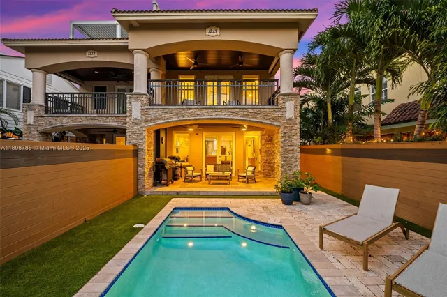 a view of a house with swimming pool lawn chairs and a yard