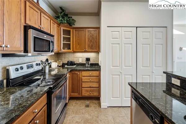 a kitchen with stainless steel appliances granite countertop a stove microwave and cabinets