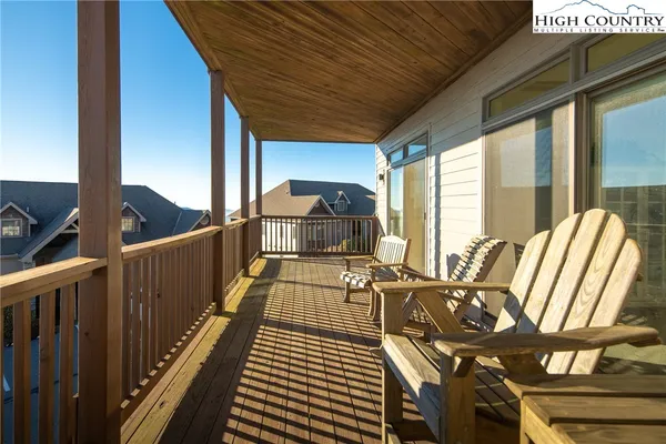a balcony with chairs and wooden floor