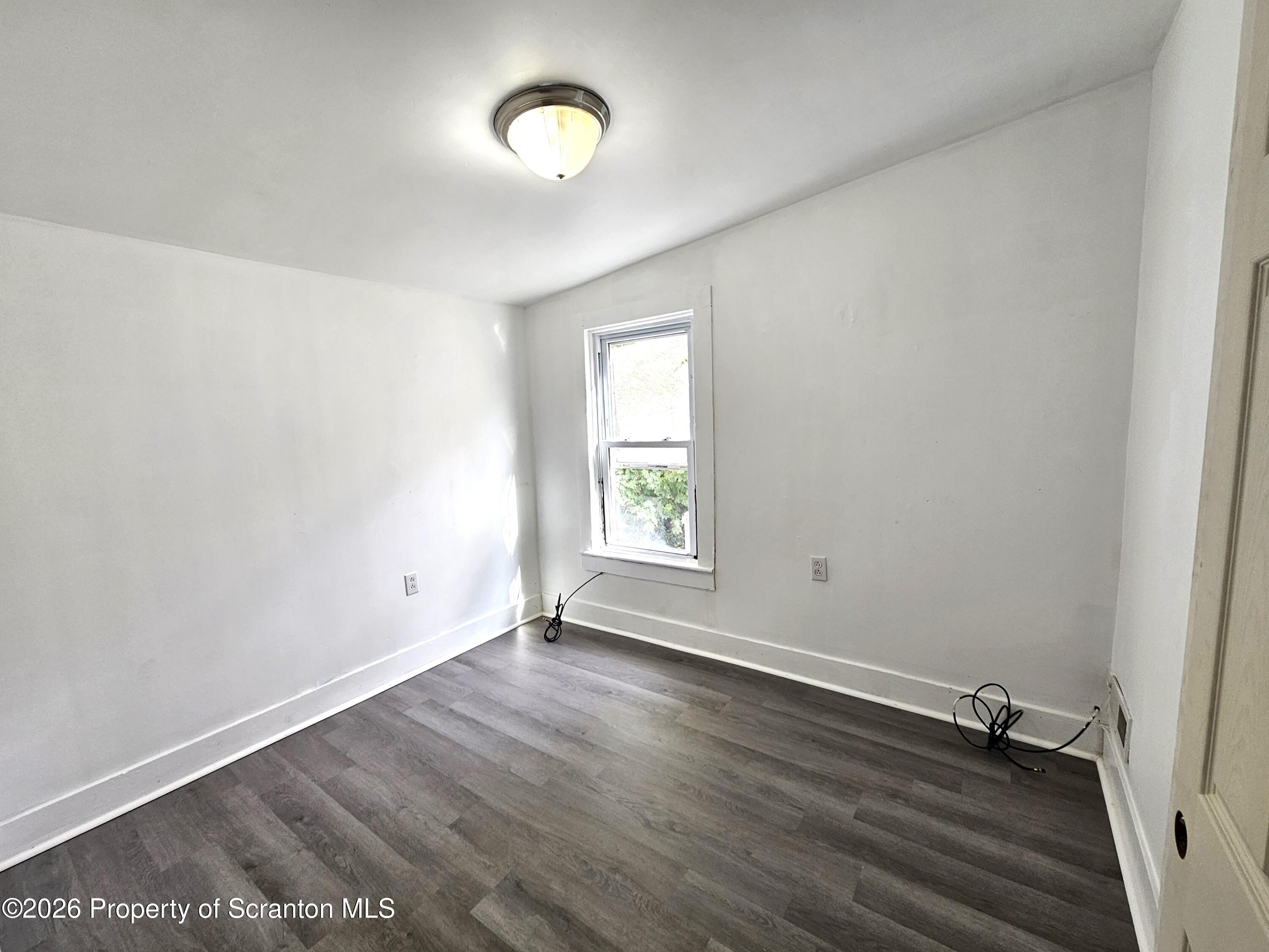 907 Green Ridge Street Scranton, PA 18509 - Photo 7 of 12 an empty room with wooden floor and windows