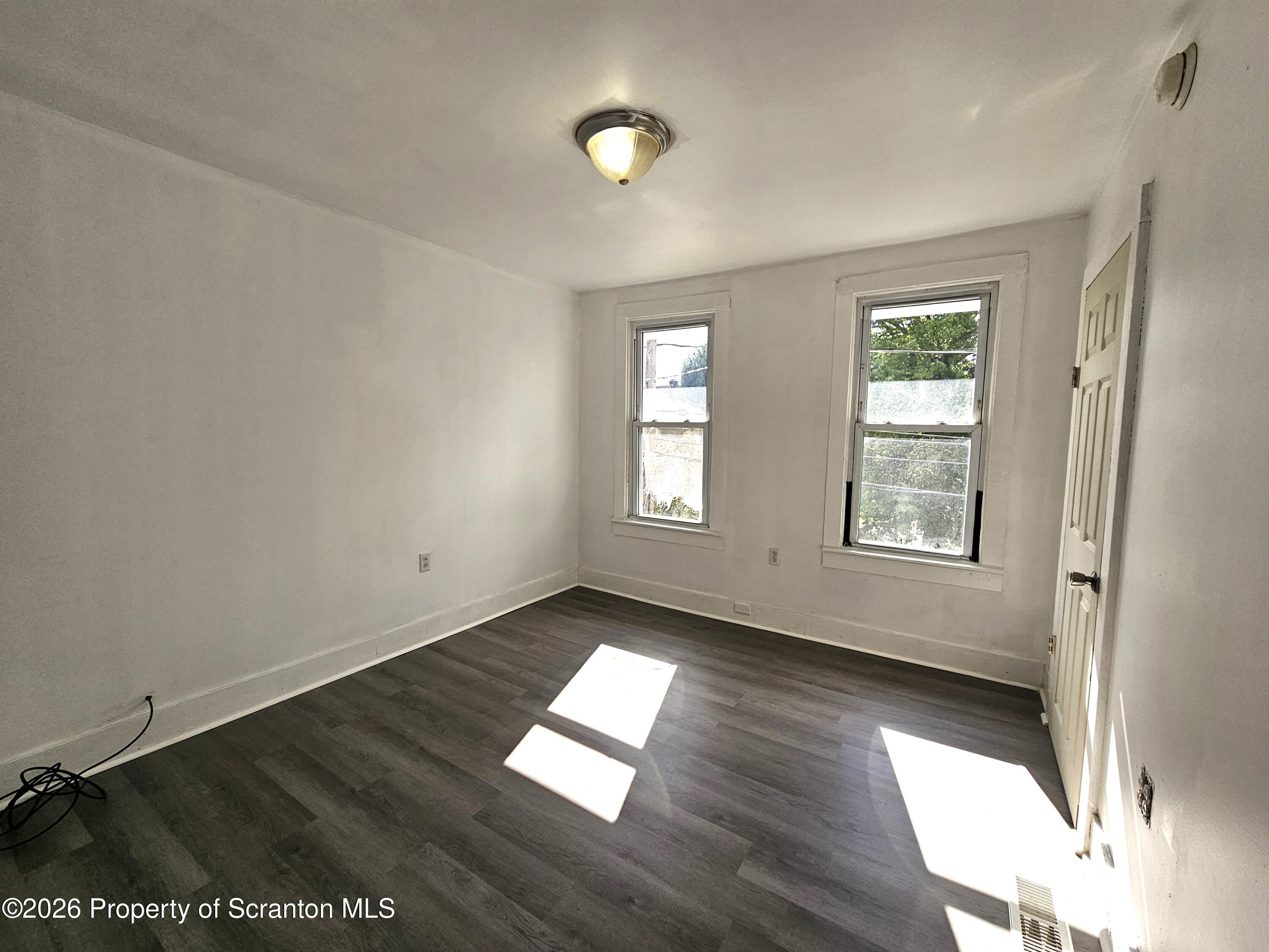 907 Green Ridge Street Scranton, PA 18509 - Photo 8 of 12 an empty room with wooden floor and windows