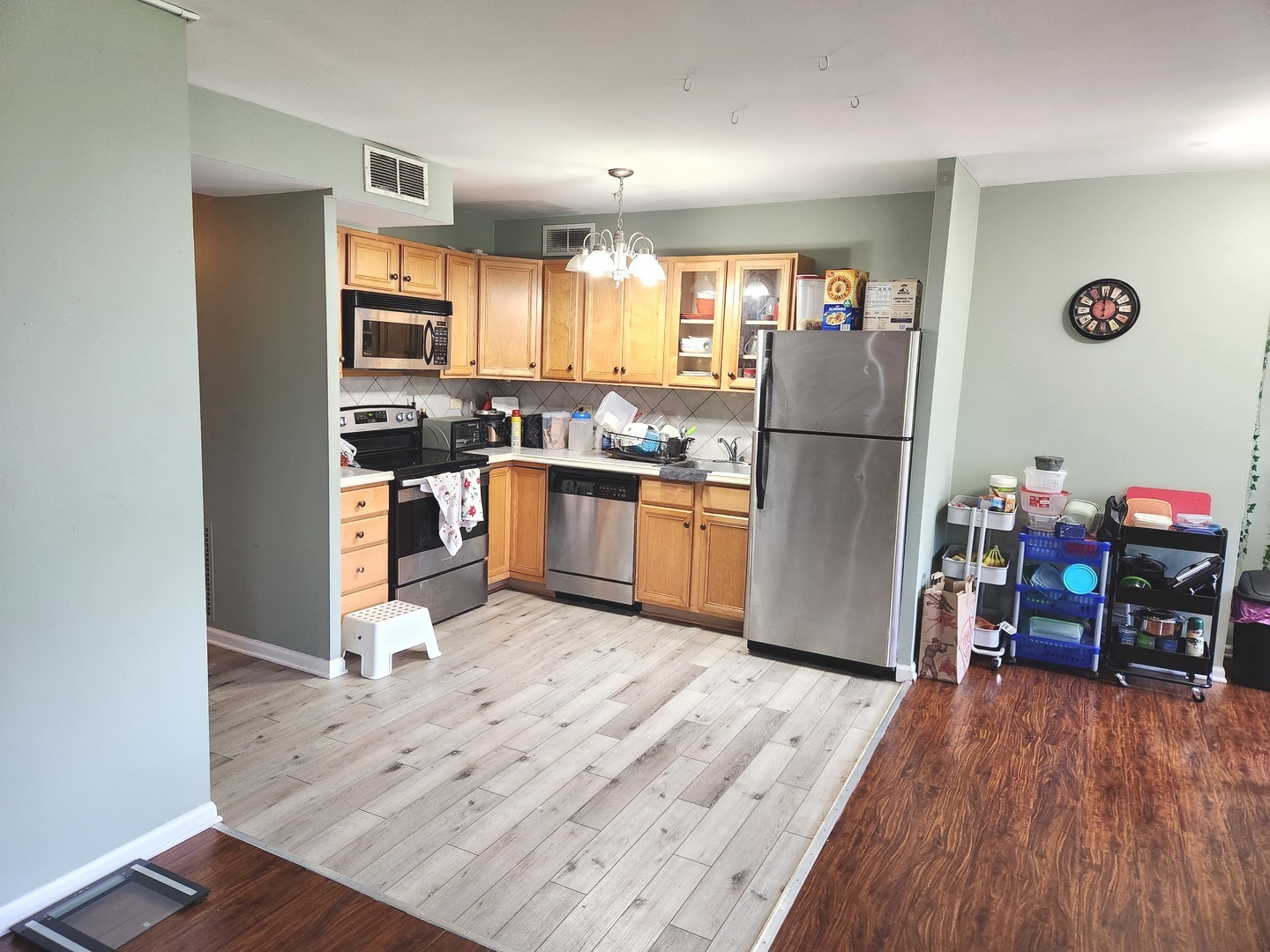 6301 North Sheridan Road, Unit 4H Chicago, IL 60660 - Photo 6 of 17 a kitchen with stainless steel appliances granite countertop a refrigerator oven a sink dishwasher and a dining table with wooden floor