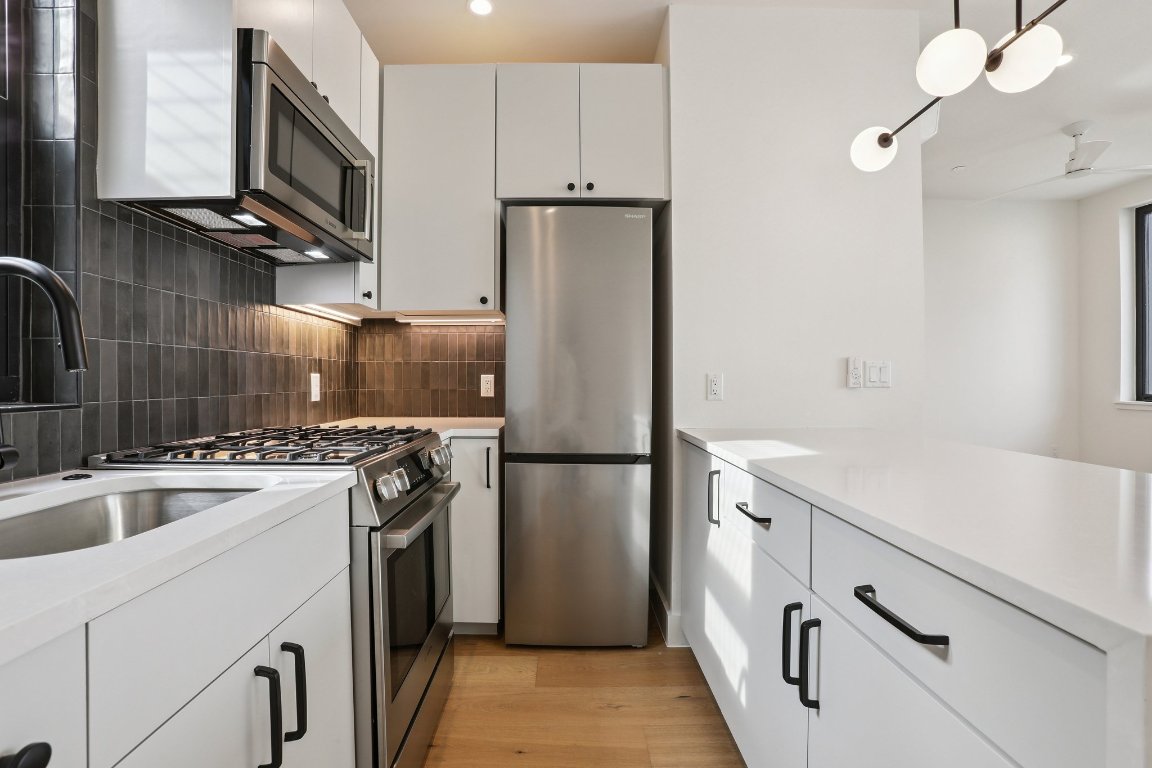 a kitchen with a refrigerator sink and stove