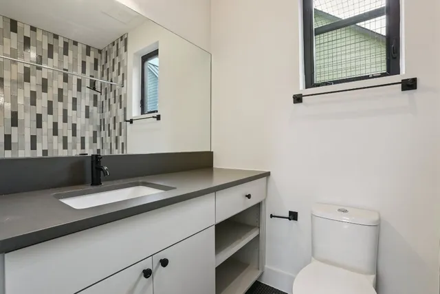 a bathroom with a granite countertop toilet a sink and a bathtub