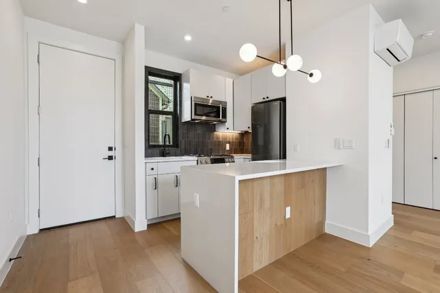 a kitchen with kitchen island white cabinets and stainless steel appliances