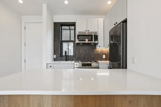 a view of a kitchen with a sink and a large window