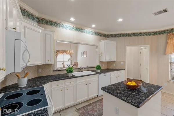 a kitchen with a sink a stove a refrigerator and cabinets