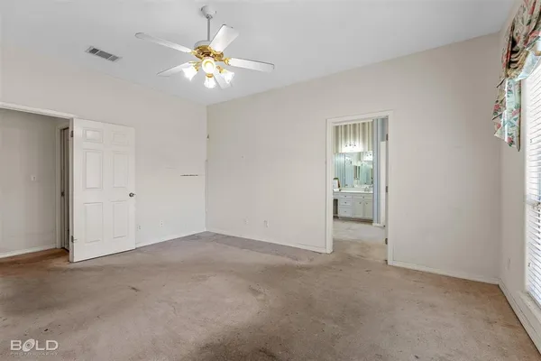 a view of an empty room with a chandelier fan