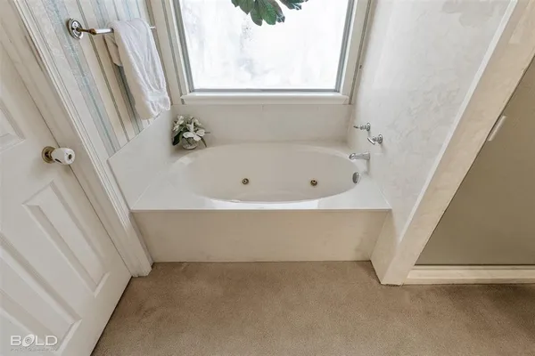 a bath tub sitting in a bathroom next to a window