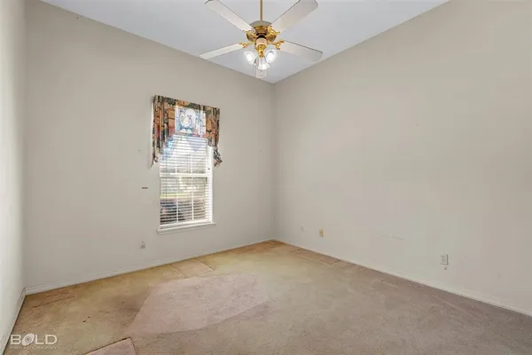 an empty room with a window and a fan