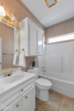 a bathroom with a granite countertop toilet a sink and bathtub