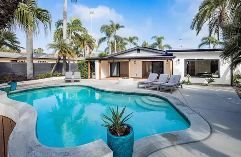 a view of a house with pool and sitting area