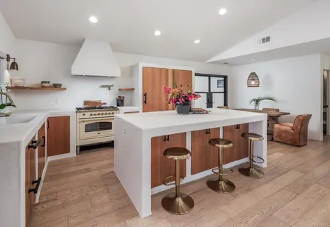 a kitchen with a stove a sink a microwave a refrigerator and white cabinets