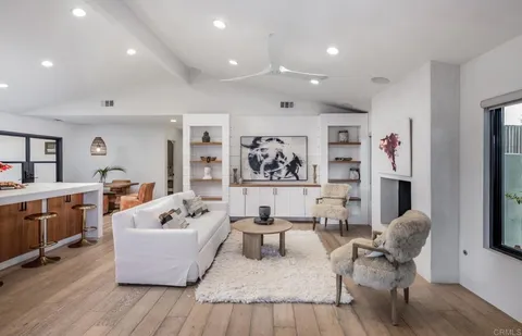 a living room with furniture a flat screen tv and a floor to ceiling window