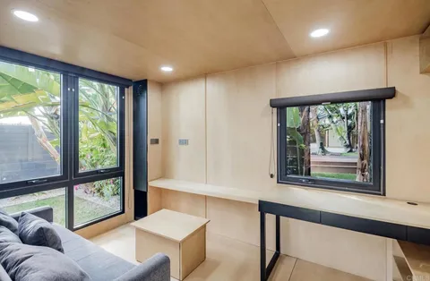 a view of a white building with a potted plants and a yard