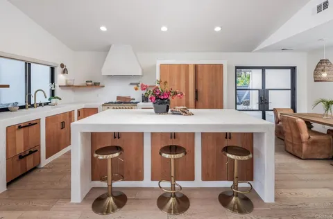 a kitchen with stainless steel appliances granite countertop a sink a stove and a wooden floor