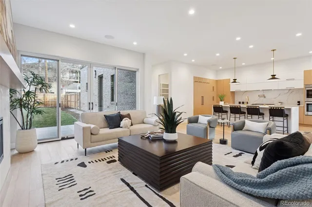 a living room with furniture kitchen view and large windows