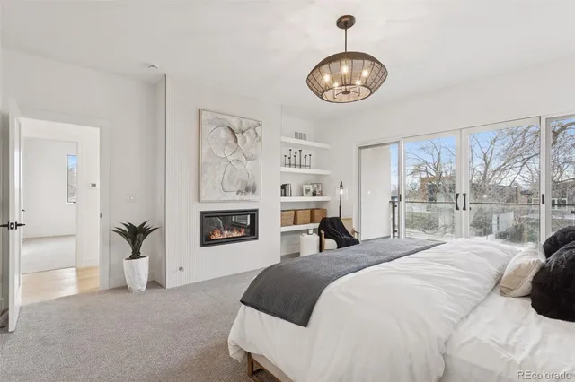a bedroom with a large bed and a chandelier