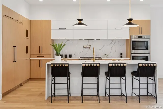 a kitchen with stainless steel appliances kitchen island granite countertop a table and chairs in it