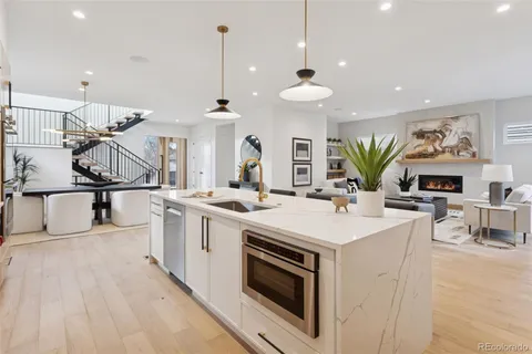a living room with furniture kitchen view and large windows