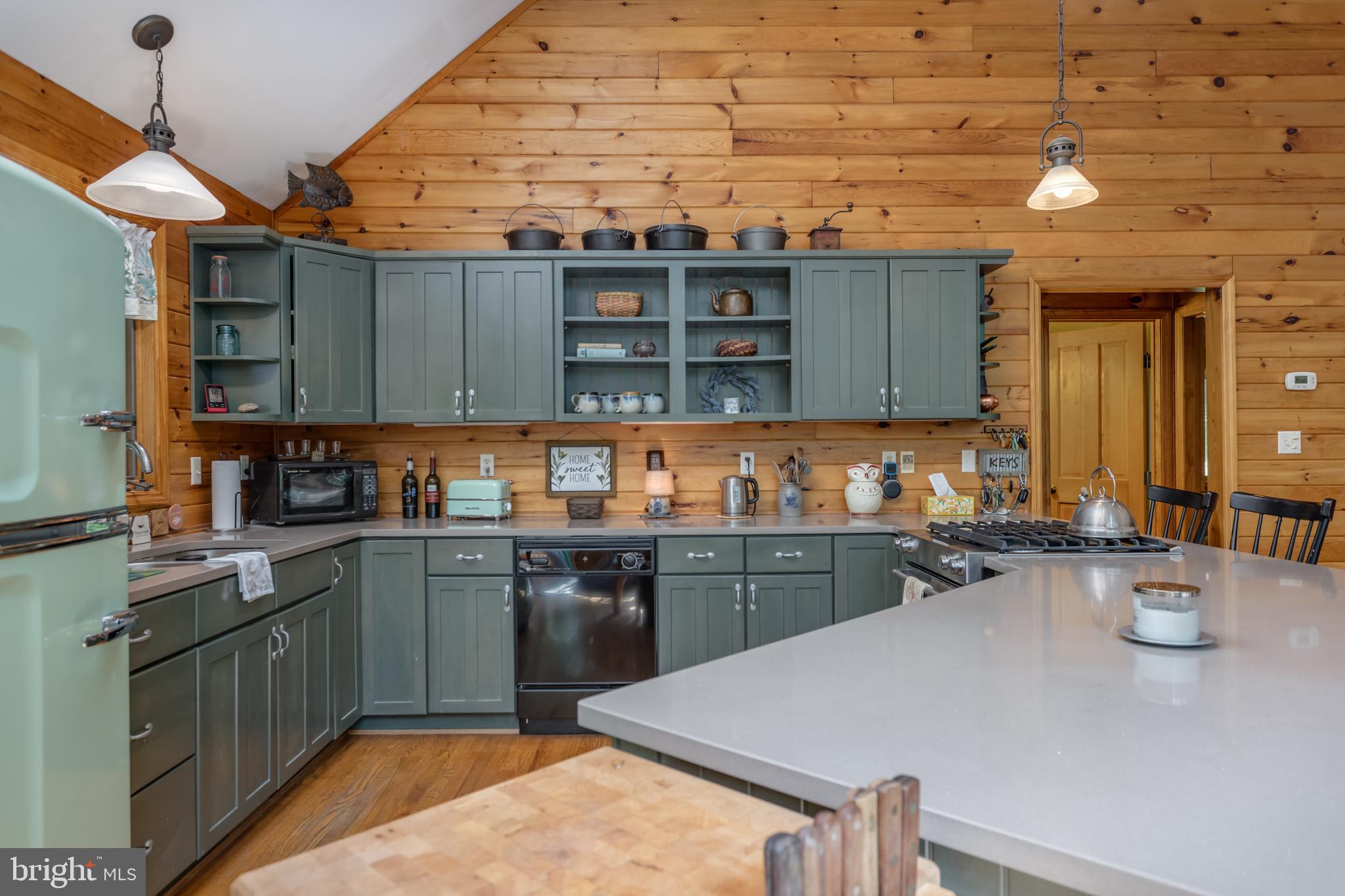 379 Wintergreen Way Berkeley Springs, WV 25411 - Photo 3 of 55 a kitchen with a stove a sink a kitchen island with chairs and wooden cabinets