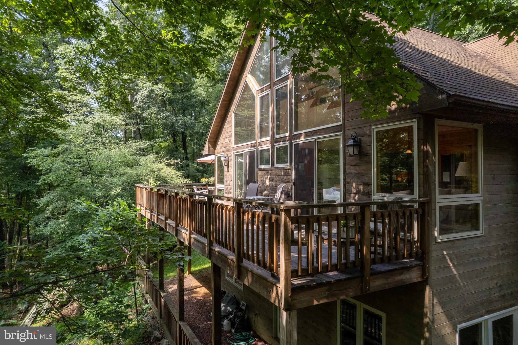379 Wintergreen Way Berkeley Springs, WV 25411 - Photo 44 of 55 a view of a house with large windows and a small yard