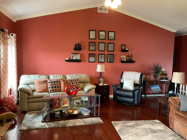 a living room with furniture a rug and a book shelf