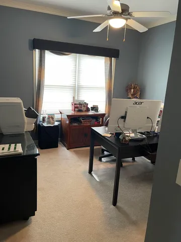 a view of a workspace with furniture and a window