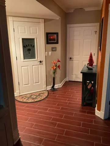 a view of an empty room with wooden floor and a painting on the wall