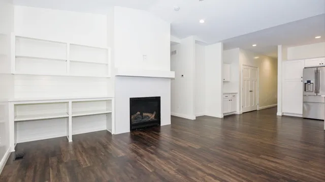 a large kitchen with stainless steel appliances kitchen island a large counter top and a wooden floors