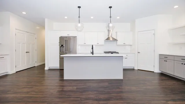 a view of a livingroom with wooden floor and a fireplace