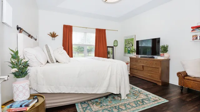 a large bed sitting in a bedroom next to a window