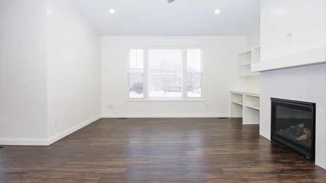 a large kitchen with stainless steel appliances a large counter top a sink a refrigerator and a window