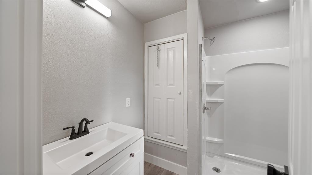 129 King Arthur Road Mabank, TX 75156 - Photo 19 of 33 a bathroom with a sink a mirror and shower