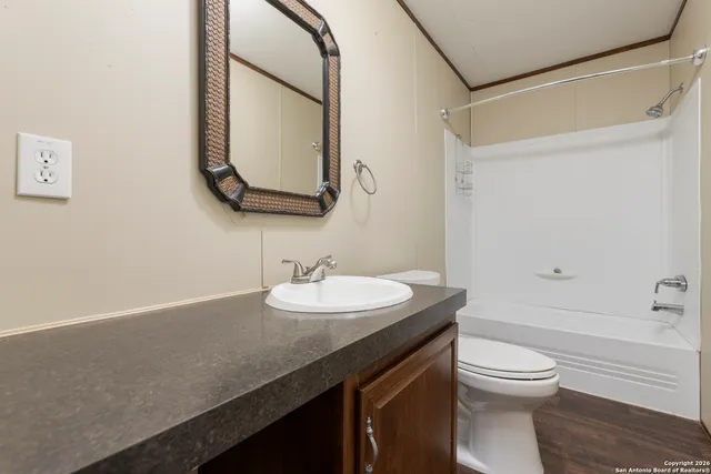 a bathroom with a granite countertop sink toilet a large mirror and shower