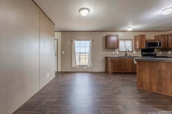 an empty room with kitchen wooden floor and windows