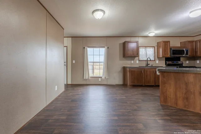 an empty room with kitchen wooden floor and windows