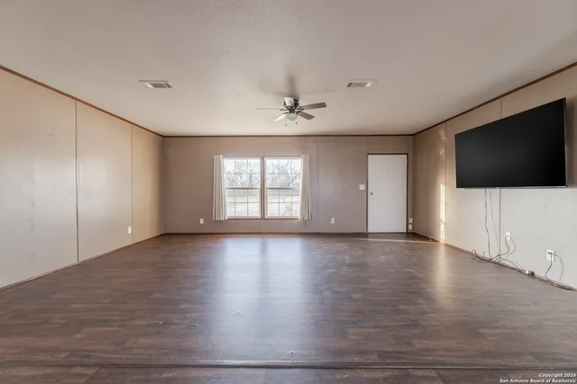 a view of a livingroom with wooden floor and a flat screen tv