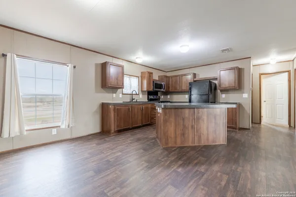 a kitchen with stainless steel appliances kitchen island wooden cabinets and granite counter tops