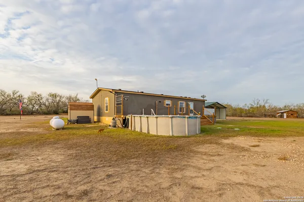 a house view with swimming pool in front of it