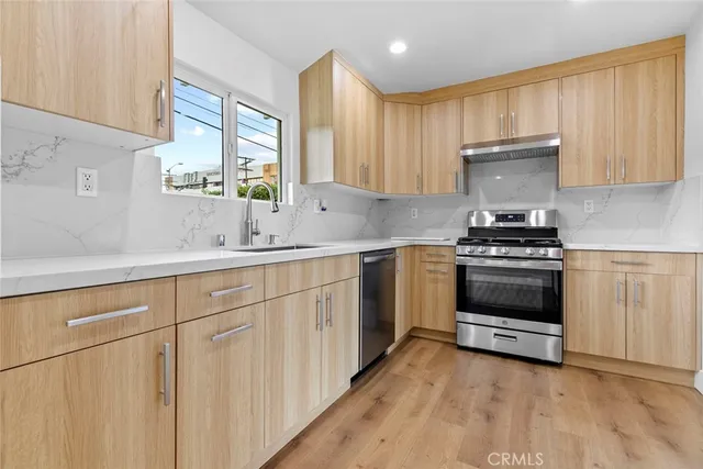 a kitchen with granite countertop a stove a sink and a microwave