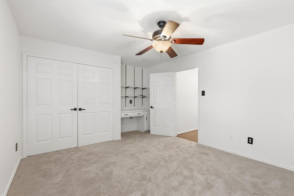 4350 Timberglen Road Dallas, TX 75287 - Photo 18 of 33 Unfurnished bedroom featuring built in study area, a ceiling fan, light colored carpet, and a closet
