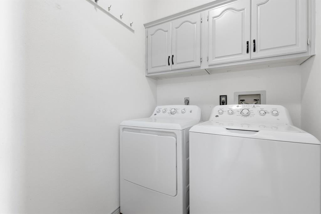 4350 Timberglen Road Dallas, TX 75287 - Photo 21 of 33 Laundry room featuring cabinet space and washer and dryer