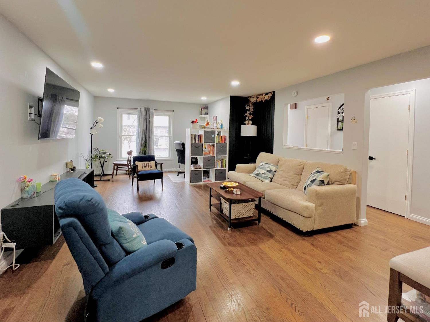 a living room with furniture and wooden floor