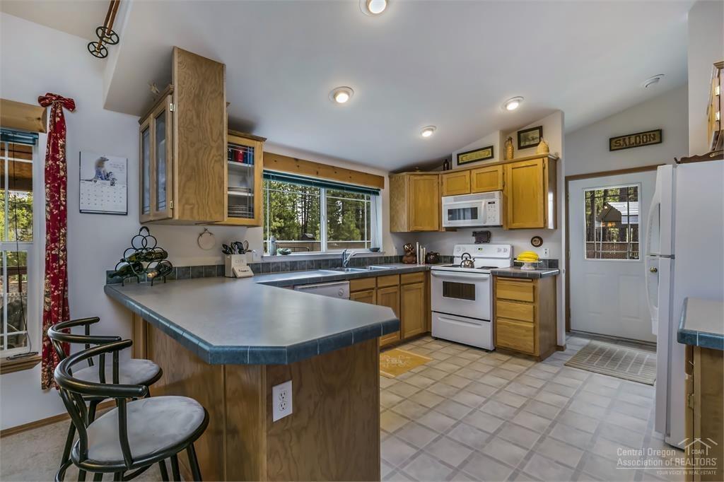 17171 Island Loop Way Bend, OR 97707 - Photo 6 of 25 a kitchen with a table chairs sink and refrigerator