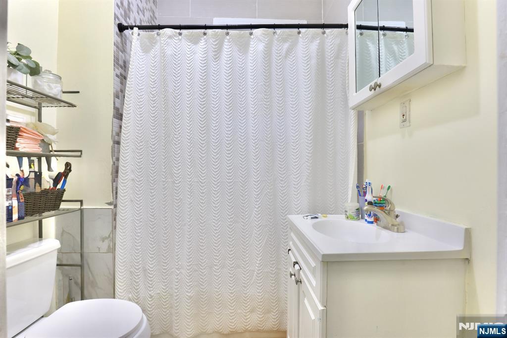 116 North 13th Street Newark, NJ 07107 - Photo 12 of 14 a bathroom with a sink a toilet and shower curtain