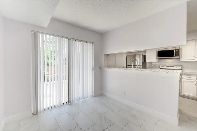 a view of kitchen with microwave and cabinets