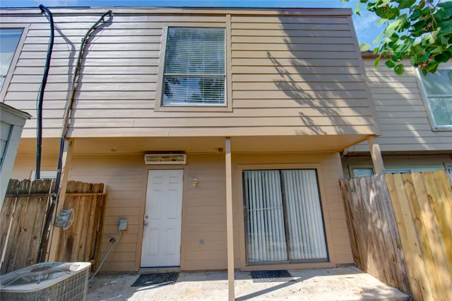 a view of a house with backyard and a tree